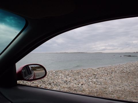 1998 Ford Taurus - Looking out the window at a rocky shoreline and the vast ocean under a cloudy sky.