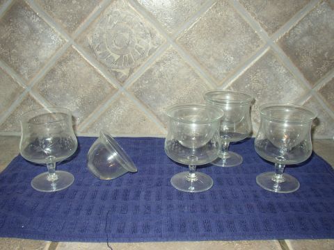 1987 Volkswagen Golf - A collection of clear glass goblets and a small bowl are displayed on a blue towel against a tiled background.