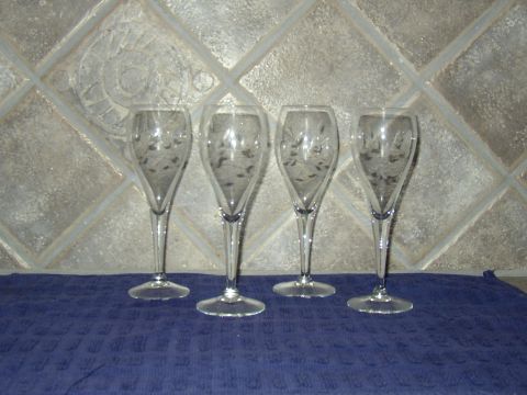 1987 Volkswagen Golf - Four etched champagne flutes are displayed on a blue cloth against a tiled background.