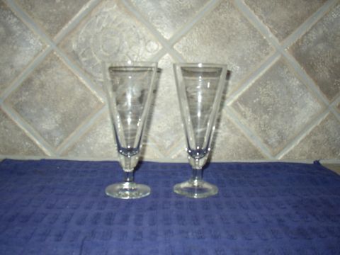 1987 Volkswagen Golf - Two tall, clear glasses with fluted sides sit on a blue cloth against a tiled background.