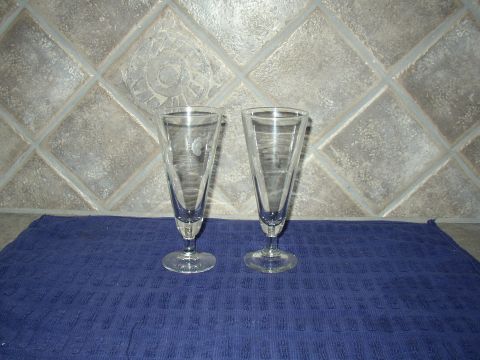 1987 Volkswagen Golf - Two clear stemmed glasses are displayed on a blue cloth in front of a tiled wall.