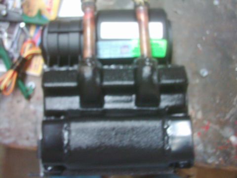 1978 Ford Bronco - Close-up of a freshly black-painted electric winch on a workbench, with copper motor terminal posts and heavy jumper straps running from th…