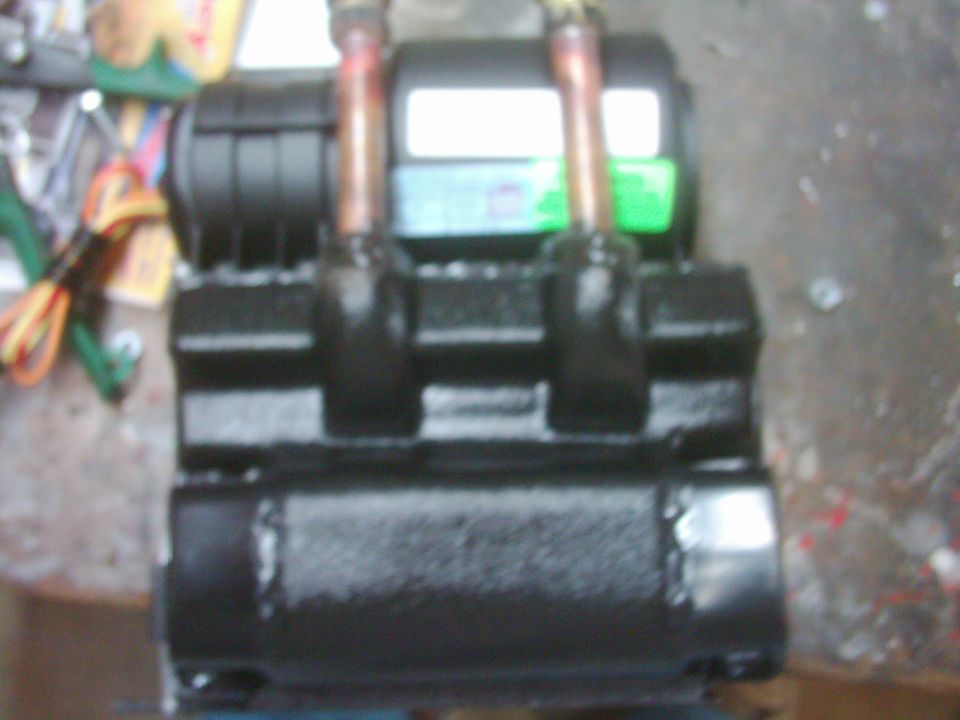 Black-painted electric winch on a bench with copper terminals and jumper straps