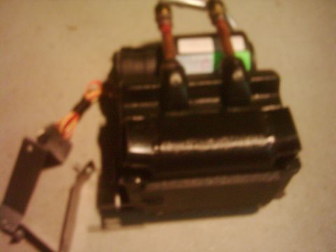 1978 Ford Bronco - Close-up of a black ignition coil with electrical wiring connected to it.