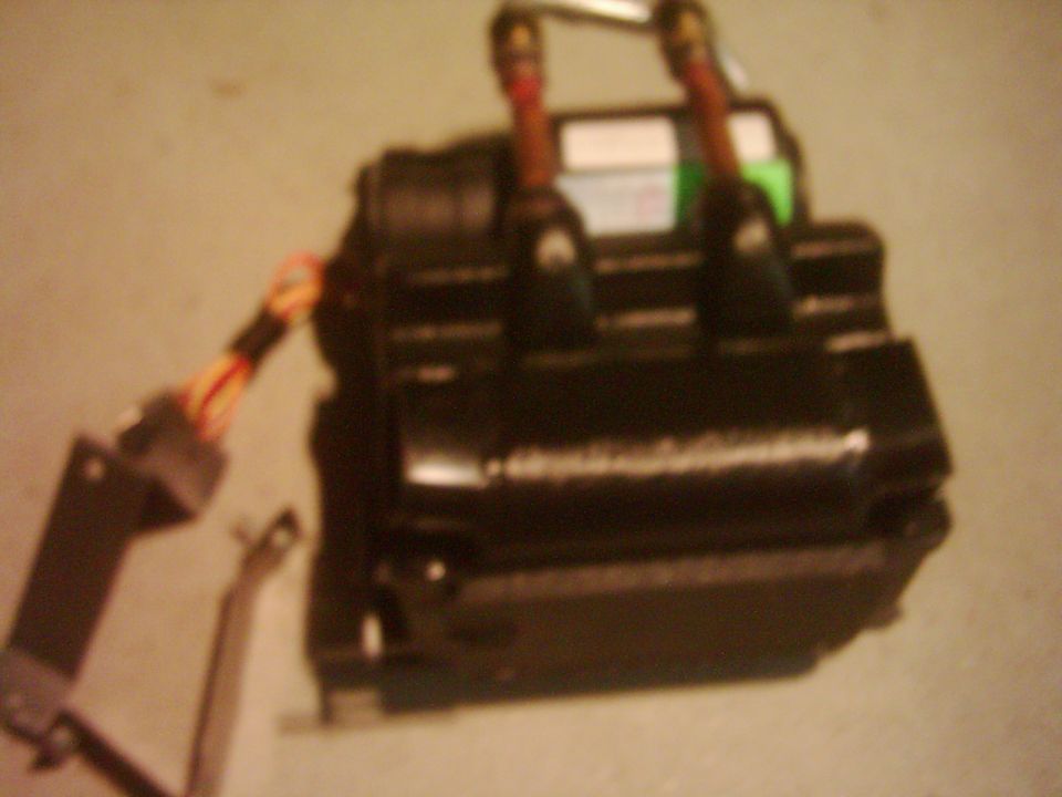black ignition coil with wires attached, some text visible on a label