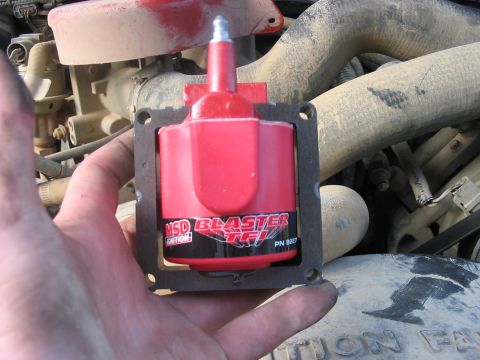1988 Ford Bronco - MSD Blaster TFI ignition coil being held, with engine parts visible behind it.