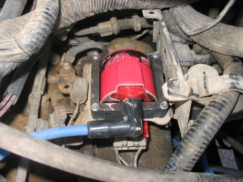 1988 Ford Bronco - Close-up view of a red MSD ignition coil with a blue spark plug wire connected.