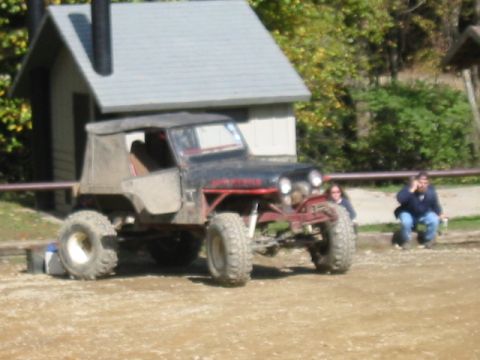1996 Ford Bronco - This modified off-road jeep features a soft top and aggressive tires, parked in an outdoor setting.