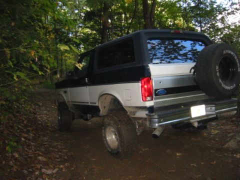 1996 Ford Bronco - This 1996 Ford Bronco is navigating a muddy, wooded path with its rear facing the camera.