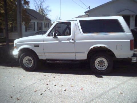 1993 Ford Bronco - This 1993 Ford Bronco is seen from the side, parked on a street with houses in the background.