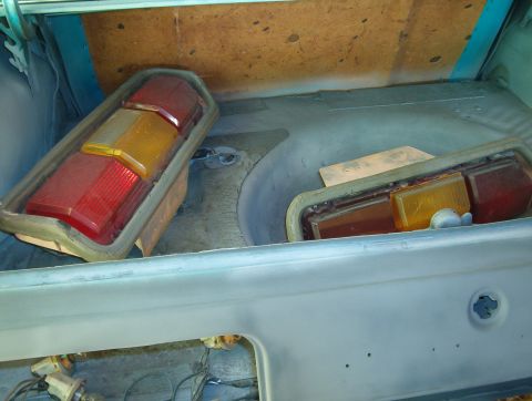 1977 Ford Mustang II - Two tail light assemblies, one red and amber, are stored in the trunk of a vehicle undergoing restoration.