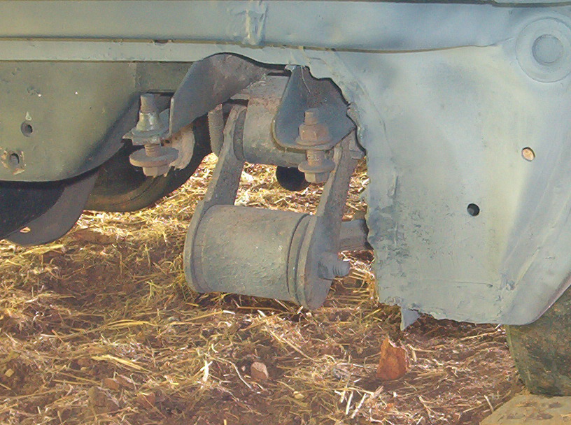Close-up of a vehicle's rear suspension component, possibly a shock absorber mount or linkage