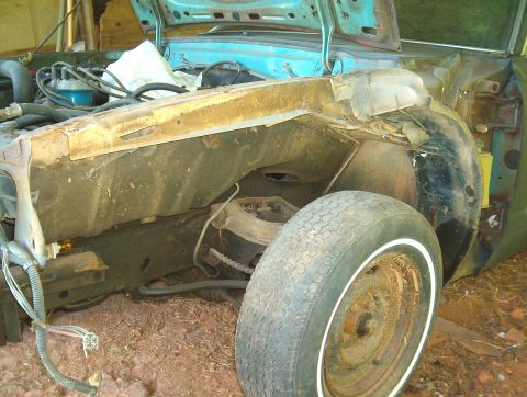 1977 Ford Mustang II - This photo shows the engine bay of a vehicle undergoing restoration, with visible rust and disassembled components.