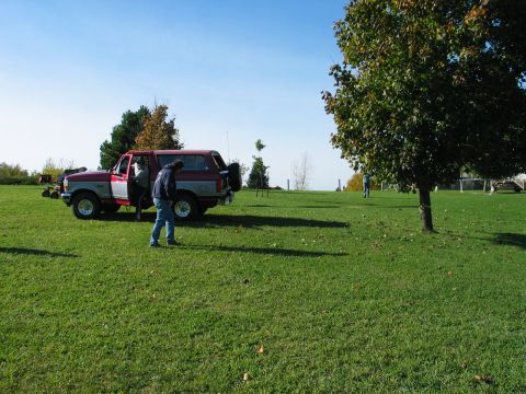 1995 Ford Bronco - An SUV is parked on a grassy field under a clear blue sky with trees in the background.