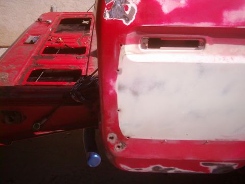 1978 Ford Bronco - Close-up of a red pickup truck's rear, showing the tailgate removed and the bed awaiting bodywork.