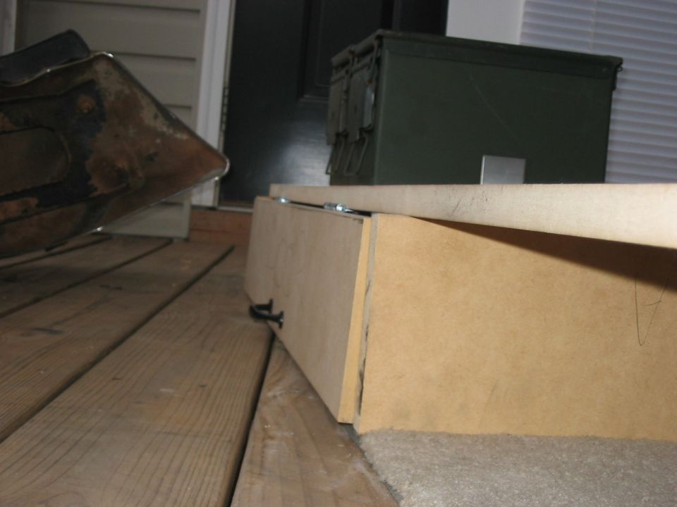 Wooden box on carpet next to an ammo can on a porch