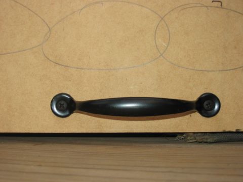 1988 Ford Bronco - A black drawer pull is mounted on a surface with drawn circles, with a SuperMotors logo at the bottom right.