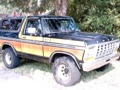 1979 Ford Bronco - This Ford Bronco has a two-tone paint scheme with a black top and a gradient of orange and yellow on the lower body.