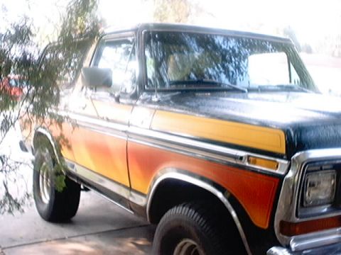 1979 Ford Bronco - This 1978 Ford Bronco features a distinctive orange and yellow side paneling with woodgrain accents.