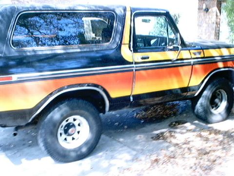 1979 Ford Bronco - This 1979 Ford Bronco features a distinctive orange and yellow stripe pattern along its side.