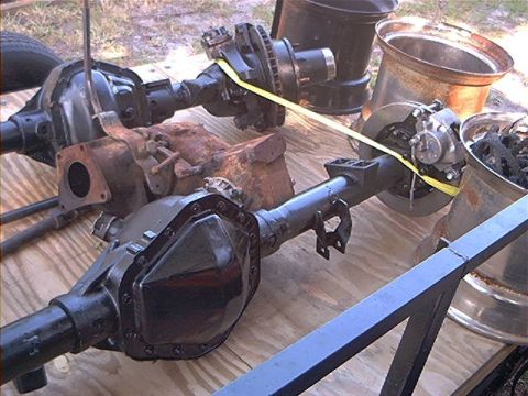 1979 Ford Bronco - Vehicle axles with brake assemblies and differential covers are laid out on a wooden surface.