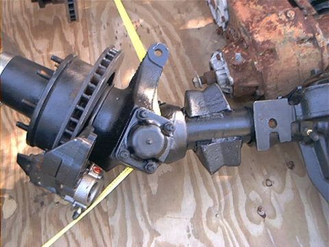1979 Ford Bronco - Close-up of a vehicle's front axle assembly, showing brake components and suspension linkage.