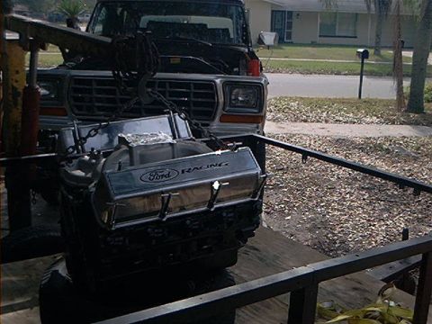 1979 Ford Bronco - The front of a 1979 Ford Bronco is visible as its engine is hoisted out for service.