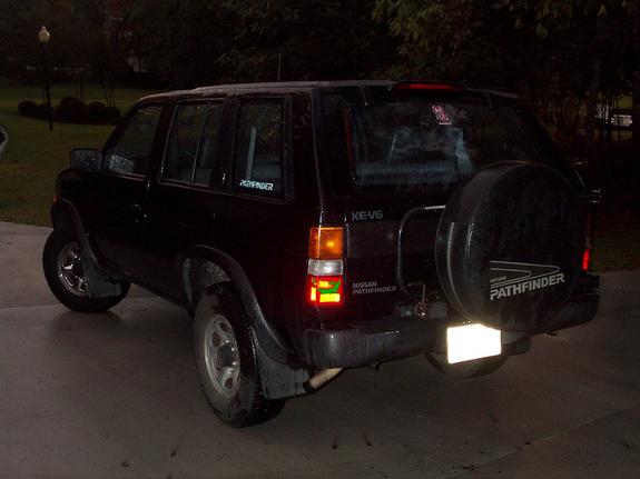 Dark Nissan Pathfinder rear three-quarter view with swing-out spare tire carrier