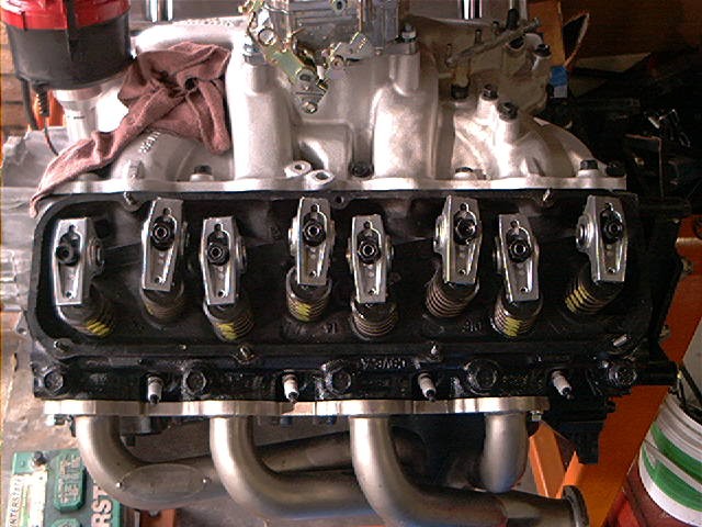 Close-up of a V8 engine's valve train with rocker arms and springs visible