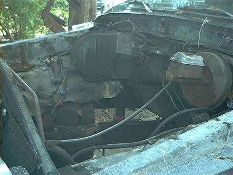 1979 Ford Bronco - The engine bay of a vehicle appears heavily damaged and rusted, with visible brake components.