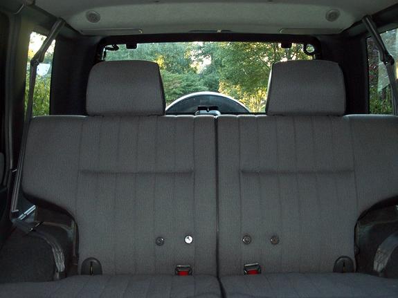 Rear bench seat of an SUV viewed from cargo area with gray cloth upholstery