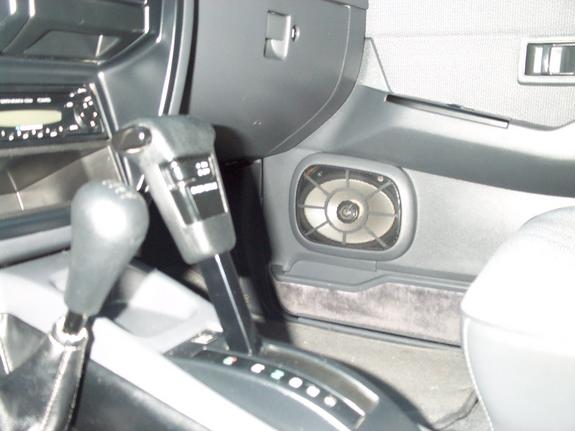 Car interior console with automatic shifter, manual shift knob, radio and floor speaker