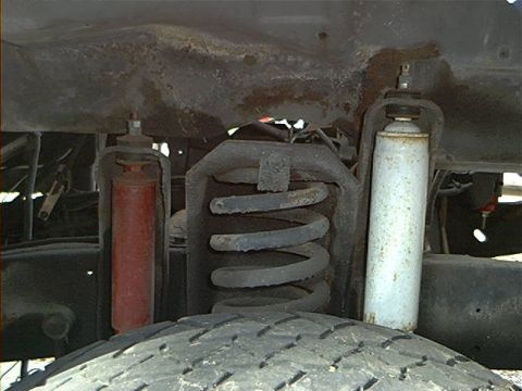 1979 Ford Bronco - The front suspension system, red and white shock absorbers and a prominent coil spring, is visible in this close-up view.