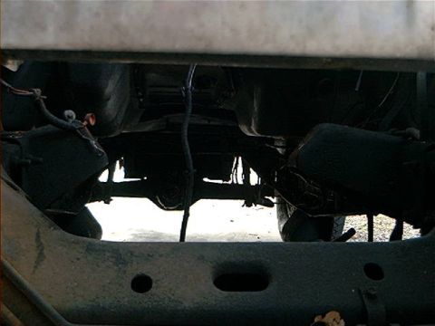 1979 Ford Bronco - Underside view of vehicle chassis with visible suspension and drivetrain parts.