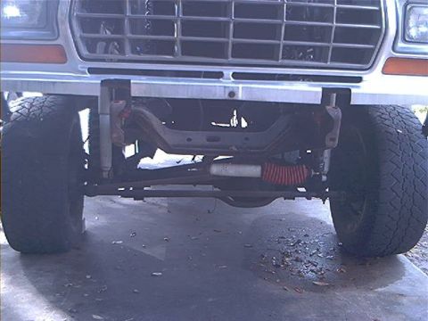 1979 Ford Bronco - Close-up of the front suspension and grille of a lifted truck.
