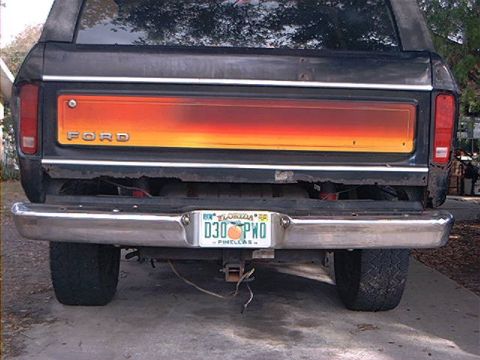 1979 Ford Bronco - Rear view of a black 1978 Ford Bronco, showing its distinctive tailgate panel and chrome bumper.
