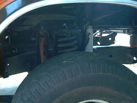 1979 Ford Bronco - Close-up view of a vehicle's suspension system and tire, with visible text "SUPERMOTORS.NET" at the bottom.
