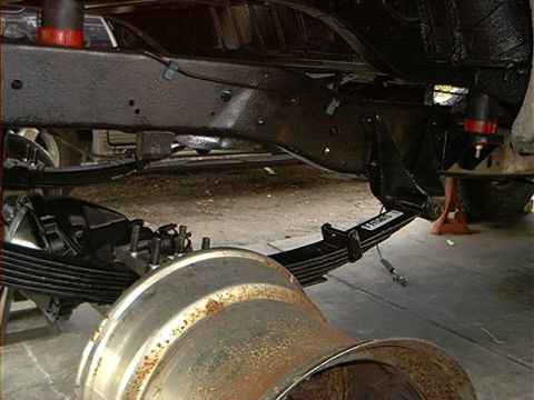 1979 Ford Bronco - Close-up view of the vehicle's undercarriage, focusing on the suspension and frame components during maintenance.