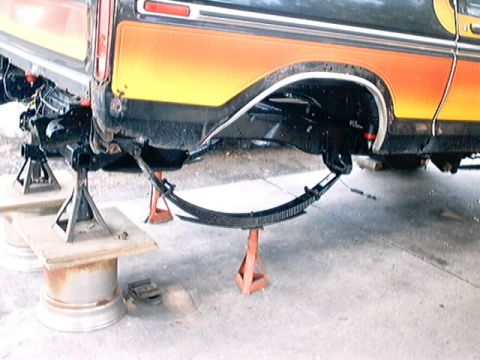 1979 Ford Bronco - The rear leaf spring suspension of a 1979 Ford Bronco is visible while supported by jack stands.