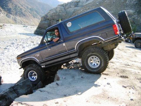 1985 Ford Bronco - Ford Bronco tackles challenging off-road terrain in a mountainous area.