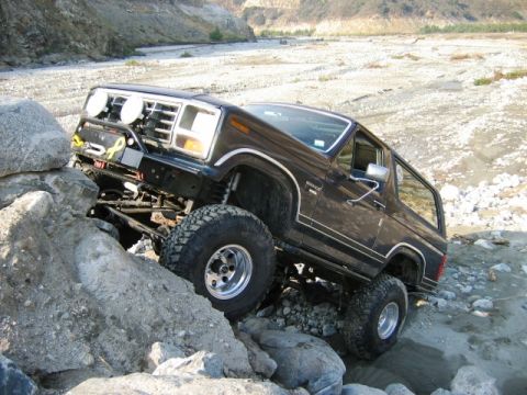 1985 Ford Bronco - This modified Ford Bronco tackles a challenging rocky path, its off-road capabilities.