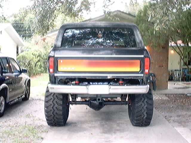 Black Ford Bronco with lifted suspension and large tires, rear view