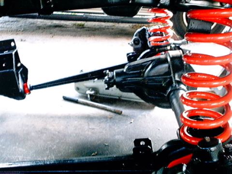 1979 Ford Bronco - Vehicle suspension parts, including red coil springs and a differential, are visible in this close-up shot.