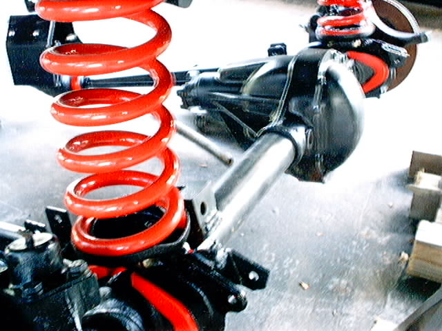 Red coil spring and black differential housing with silver axle shaft