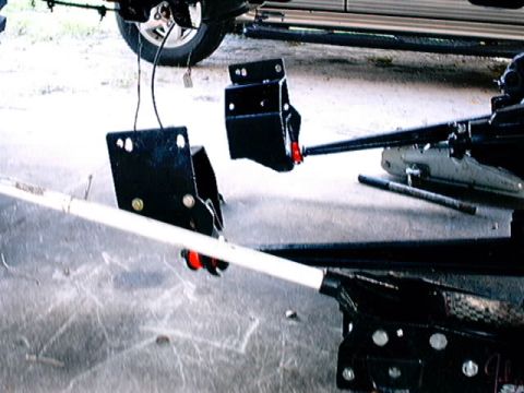 1979 Ford Bronco - Close-up view of black suspension parts, possibly for a truck or SUV, with visible red accents and a white bar.