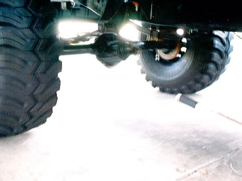 1979 Ford Bronco - The underside of a vehicle, focusing on its heavy-duty tires and drivetrain components.