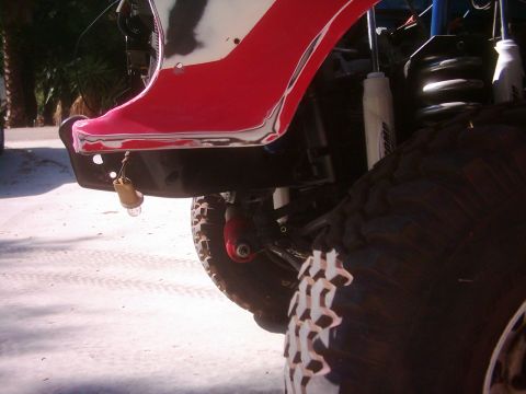 1978 Ford Bronco - Close-up view of a vehicle's fender and tire, showing exposed metal and a dangling light bulb.