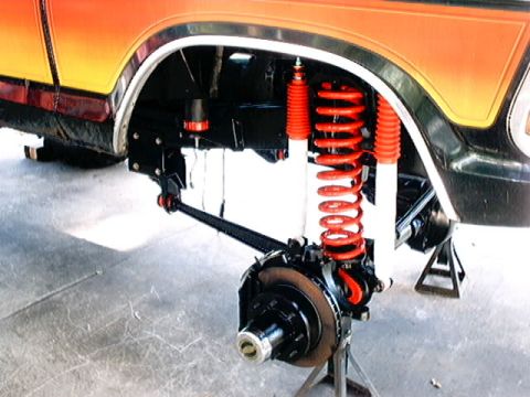 1979 Ford Bronco - Front suspension and wheel assembly of a 1979 Ford Bronco, showing upgraded shocks and brakes.