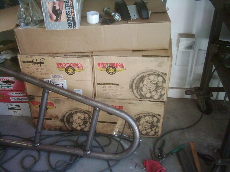 Metal roll cage part in front of stacked Mickey Thompson wheel boxes