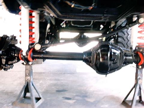 1979 Ford Bronco - The underside of a vehicle is shown, highlighting its lifted suspension and heavy-duty components.